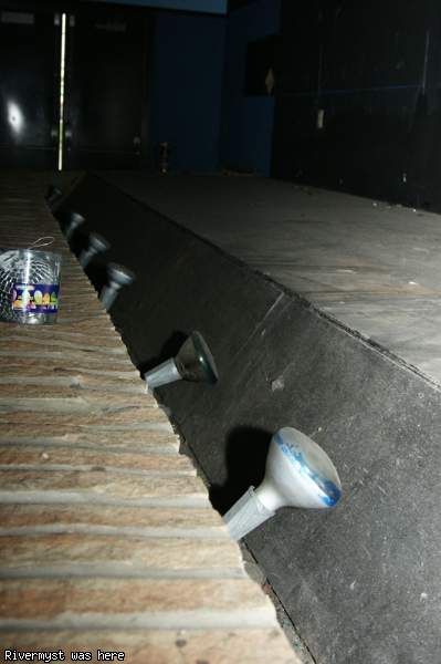 Close-up of the old light bulbs running along the edge of an auditorium stage.